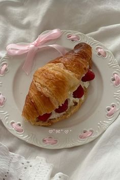 a croissant with cream cheese and strawberries on it is sitting on a plate