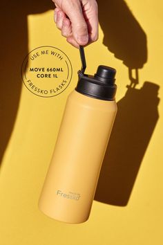 a hand holding a black straw in front of a yellow background with the words fresho written on it