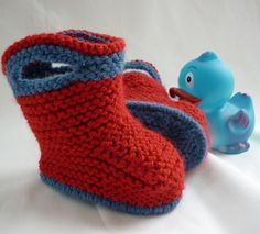 a pair of red and blue knitted shoes next to a rubber duck