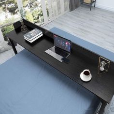 a laptop computer sitting on top of a wooden desk next to a cup of coffee