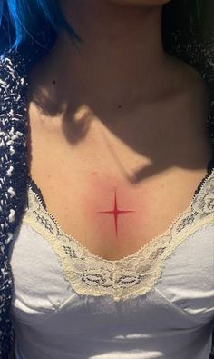 a woman with blue hair has a cross on her chest