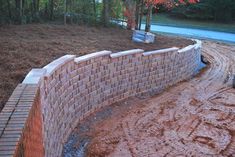 a brick wall in the middle of a dirt road