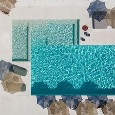 an aerial view of a pool with umbrellas and chairs