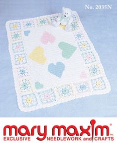 a crocheted baby blanket with hearts on it and a teddy bear in the middle