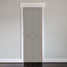 an empty room with a white door and wooden floor