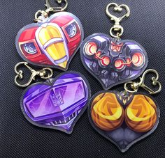 three heart shaped key chains with different designs on them