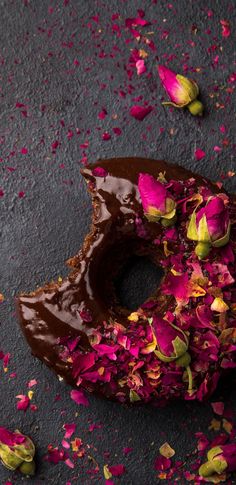 a chocolate doughnut with pink flowers on it