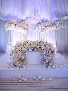 a white wedding cake surrounded by flowers and candles