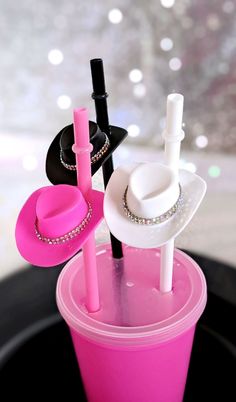 a pink cup with some black and white items in it