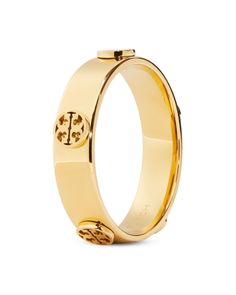 Tory Burch Miller Logo Studded Band Ring in 18K Gold Plated Designer Gold Jewelry With Gold-tone Hardware, Designer Yellow Gold Jewelry With Gold-tone Hardware, Designer Yellow Gold Jewelry With Logo, Gold Jewelry With Logo For Anniversary, Gold Jewelry With Gold-tone Logo Plaque For Anniversary, Classic Yellow Gold Jewelry With Gold-tone Hardware, Gold-tone Logo Plaque Jewelry For Anniversary, Timeless Yellow Gold Jewelry With Logo Plaque, Timeless Yellow Gold Jewelry