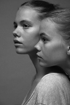 two women standing next to each other in black and white