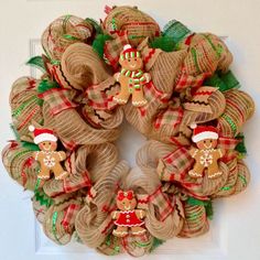 a burlock wreath decorated with christmas decorations and gingerbreads on the front door