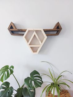 a wooden shelf sitting on top of a wall next to potted plants and a planter