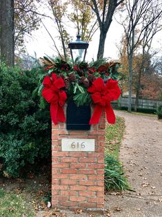 a brick mailbox decorated with poinsettis and pine cones