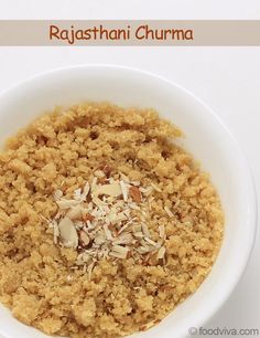 a bowl filled with rice and nuts on top of a white tablecloth next to a spoon