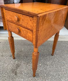 an old wooden table with two drawers on the bottom and one drawer at the top