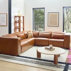 a living room filled with lots of furniture next to a large window and bookshelf