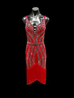 a red dress with sequins and beads on the neck, in front of a black background