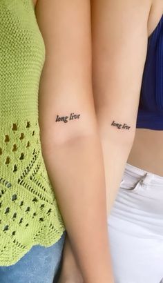 two women with tattoos on their arms and one has the words, long live love