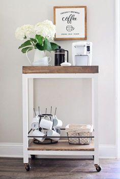 a white table topped with lots of items on top of a hard wood floor next to a wall