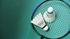 two badminton racquets sitting next to each other on a tennis court,