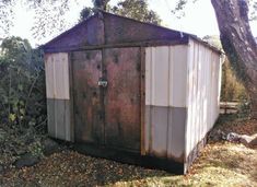 an outhouse in the middle of a wooded area