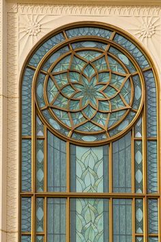 an ornate stained glass window on the side of a building with gold and blue trim