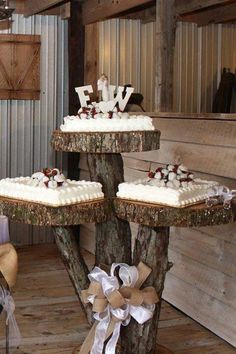 three tiered wedding cake on tree stumps decorated with ribbons and bow for the bride and groom