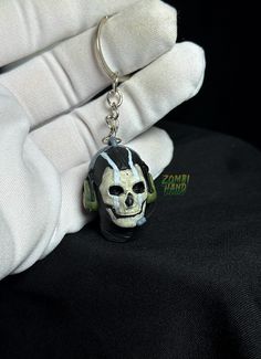 a skull keychain sitting on top of a white glove