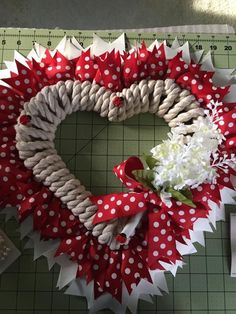 a red and white wreath on top of a cutting board