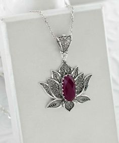 Introducing our stunning handcrafted filigree art blossoming lotus flower figured pendant necklace, featuring a breathtaking ruby corundum gemstone. This elegant necklace is made of high-quality 925 sterling silver and measures 20 inches in length, with a pendant height of 1.70 inches and a width of 1.20 inches. The July birthstone ruby corundum gemstone is a faceted oval cut that measures 7.00x14.00 mm, adding a touch of luxury to this already exquisite piece. Each necklace comes with a silver Elegant Flower Pendant Necklaces With Natural Stones, Exquisite Gemstone Flower Pendant Necklace, Elegant Flower Pendant Jewelry With Natural Stones, Elegant Lotus Flower Jewelry Gift, Elegant Ruby Jewelry With Natural Stones, Teardrop Pendant Necklace With Intricate Design For Gift, Intricate Teardrop Pendant Necklace As Gift, Exquisite Ruby Pendant Necklace, Elegant Ruby Necklaces With Natural Stones