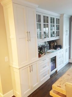 the kitchen is clean and ready to be used for wine tasting or entertaining, with all white cabinetry