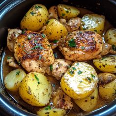 chicken and potatoes in a crock pot with parsley on top, ready to be eaten