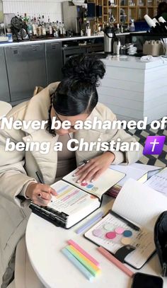 a woman sitting at a table writing on a book