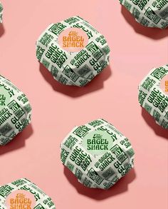 several rolls of bread sitting on top of a pink surface with the words bagel shack printed on them