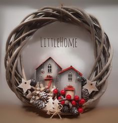 a christmas wreath with two houses and stars on it that says littlehome in the center