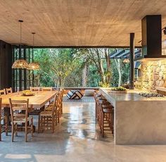 an open kitchen and dining room area with stone walls, flooring and large windows