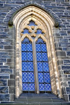 an old church window with blue glass in the front and side windows on both sides