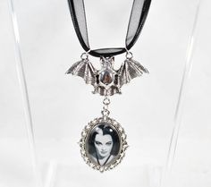 Looking for a goth glam accessory to add to your goth aesthetic? Try this black triple layer ribbon necklace with a silver toned metal Victorian cameo pendant that is 1.5 inches tall by 1 inch wide! The bat silver toned charm holds Lily's image in a silver tone cameo. Perfect for anyone who is a true goth queen! :) Black Tri Ribbon Necklace. Adjustable 16-18 inches. Black Waxed cord. Black Victorian Gothic metal charm sealed in glass. Measurements: 16-18 Inches Adjustable 2 inches by 1 1/2 inches - Pendant Bat Charm 1 inch tall by 1 3/4 inches across  *May contain minor flaws or imperfections from being handmade such as marks, spots, glares, dark marks, sparkles, bubbles, shimmer, shadows etc which are intentional  *If you have any issues or questions always message us first! Goth Queen, Lily Images, Metal Bat, Victorian Cameo, Goth Glam, Queen Black, Black Clothes, Gothic Victorian, Gothic Metal