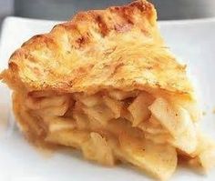 a piece of pie sitting on top of a white plate next to a sign that says mom's apple pie recipe