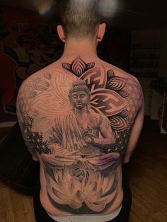 the back of a man's body with tattoos on it, and an image of a buddha