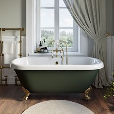 a bath tub sitting next to a window with curtains on either side and a rug in front of it