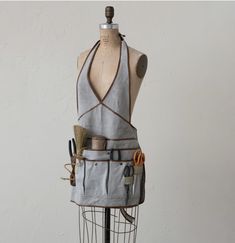 a mannequin with various tools on it's back and neck, including an apron