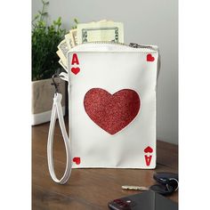 Looking to have an ace up your sleeve? This Ace of Hearts Purse is exactly what you need! The purse is designed to look like a classic playing card and comes with enough space inside for your necessities for the evening. The wrist strap makes it easy to carry, so you'll be ready with an ace at any event! Queen Of Hearts Wig, Ace Of Hearts Card, Queen Of Hearts Makeup, Ace Ventura Costume, Queen Of Hearts Card, Card Costume, Kiss Costume, Hearts Card, Heart Costume