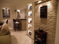 a living room filled with furniture next to a brick wall covered in pictures and lights