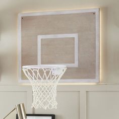 a basketball hoop hanging from the side of a wall above a table with a framed photograph on it