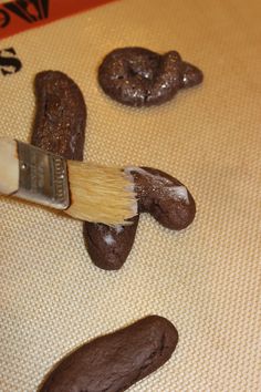 a paintbrush is being used to decorate chocolate cookies