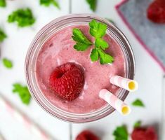 a smoothie with raspberries and mint on top