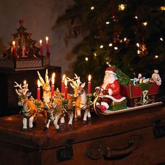 a santa clause sleigh with reindeers and candles