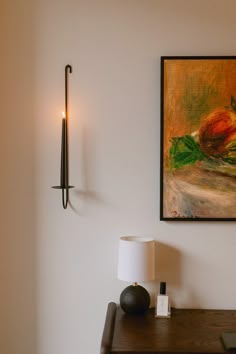 a painting hanging on the wall next to a lamp